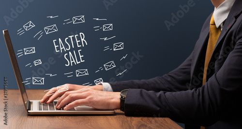 Businessman working on laptop with EASTER SALE inscription, online shopping concept