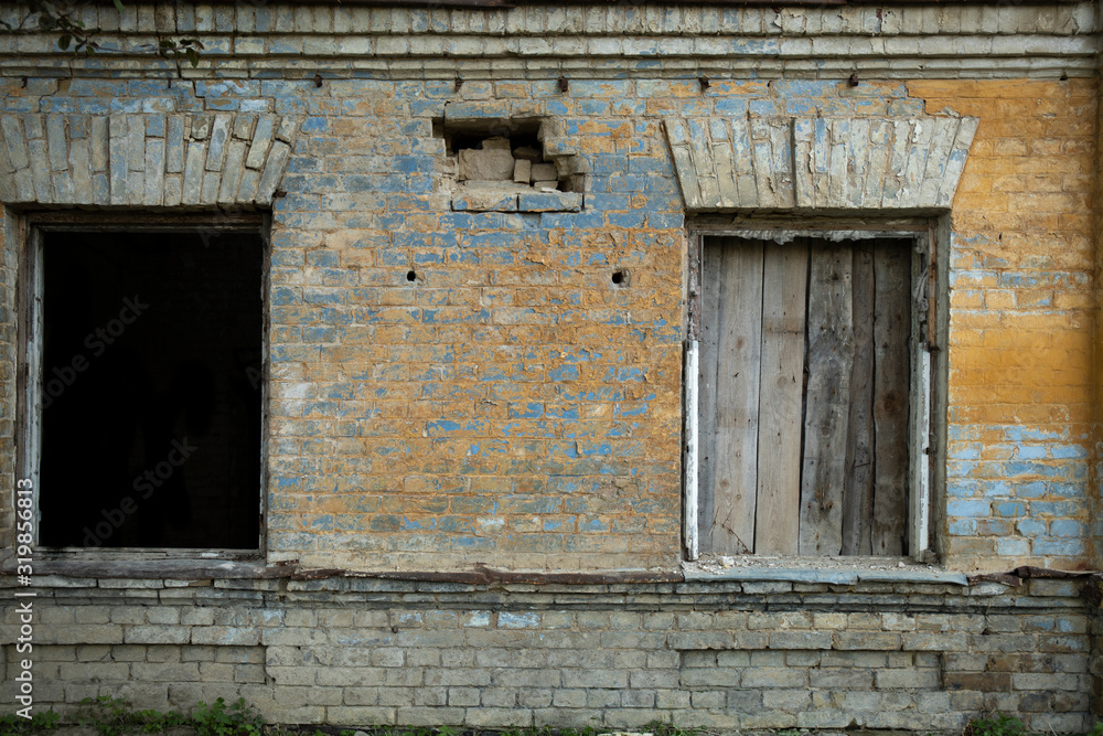 Part of abandoned building with two broken windows