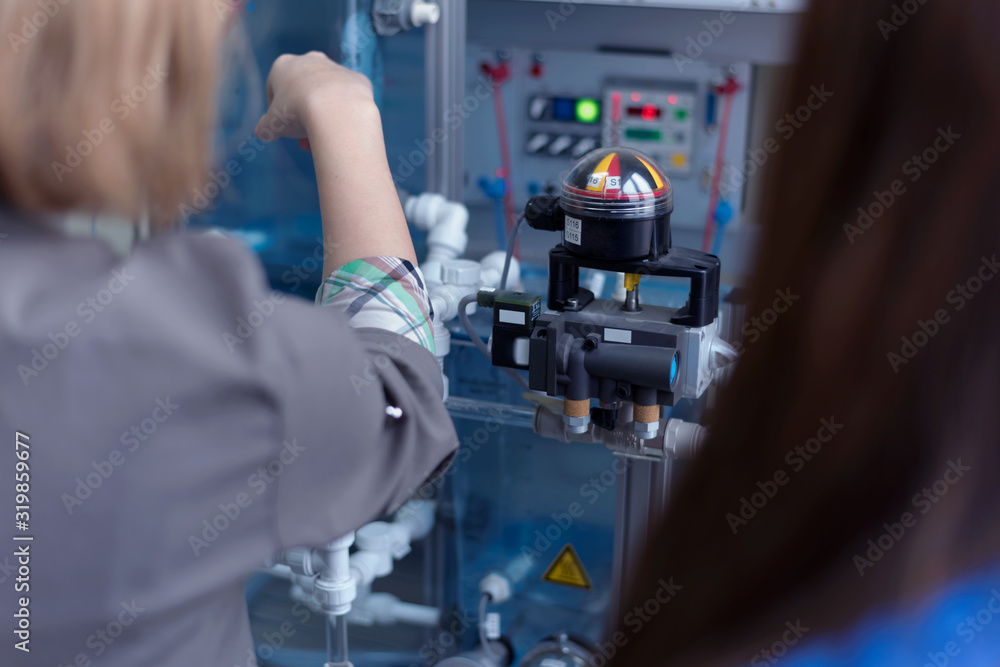 Engineering students working in the lab. Students are adjusting an electrical's components inside lab. Engineering students working in the lab. Students are adjusting an electrical's components inside lab.