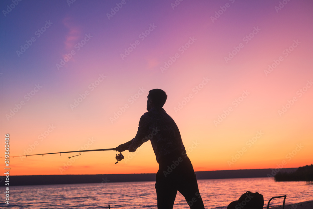 fisherman silhouette with pink sky and river
