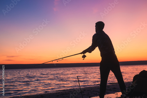 fisherman silhouette with pink sky and river