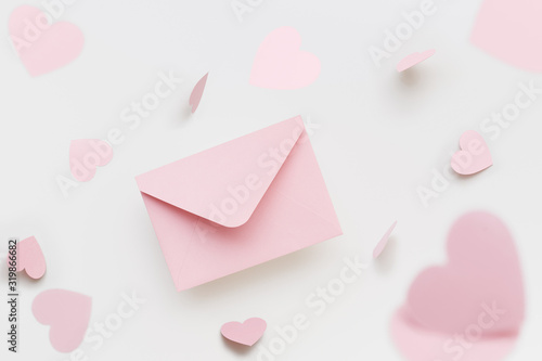 Flying pink envelope surrounded with flying pink hearts on the white background. Valentine's Day greeting concept