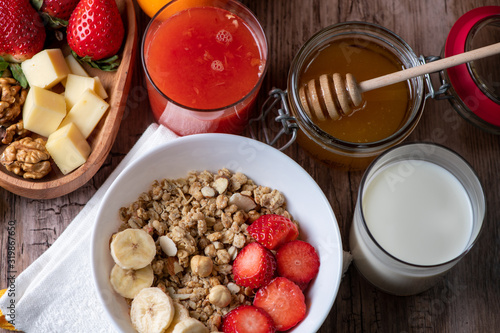 healthy breakfast with milk, muesli, honey and strawberries 