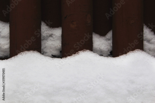 Brown wooden fence details with wavy snowdrifts