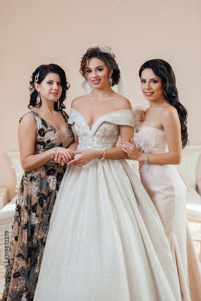 Beautiful bride in luxury wedding dress and pretty sister bridesmaids in dresses in a morning Fashion modern wedding photo. Beauty girls hairstyle and make up. Stock-foto | Adobe Stock