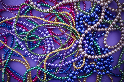 Background of colorful mardi gras beads including gold, green and purple