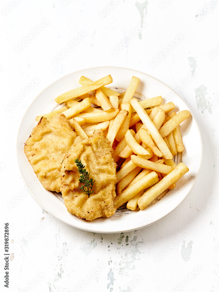 Pork Schnitzel with french fries on bright wooden background. Copy space. Pork Schnitzel with french fries on bright wooden background. Copy space.