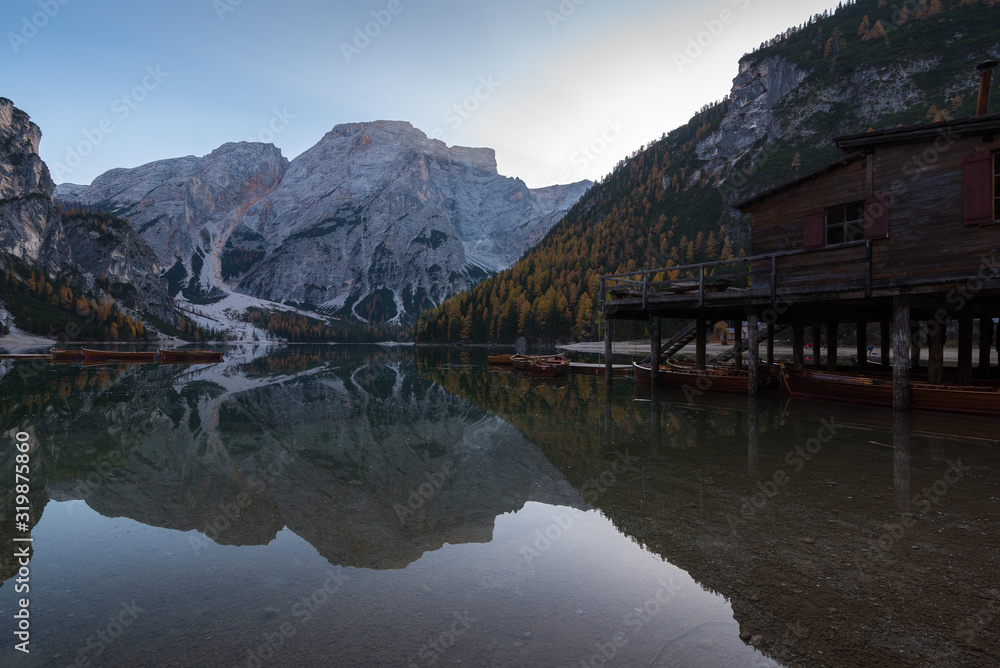 Typical scenery of Braies Lake Pragser Wildee duuring autumn with water reflections boats mountains hut trees foliage Typical scenery of Braies Lake Pragser Wildee duuring autumn with water reflections boats mountains hut trees foliage