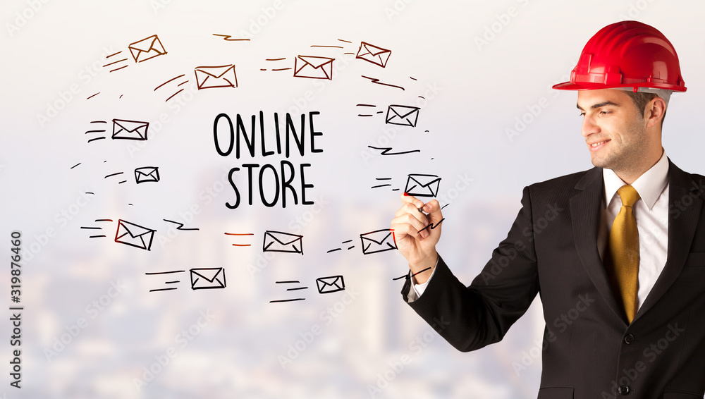 Handsome businessman with helmet drawing ONLINE STORE inscription, contruction sale concept Handsome businessman with helmet drawing ONLINE STORE inscription, contruction sale concept