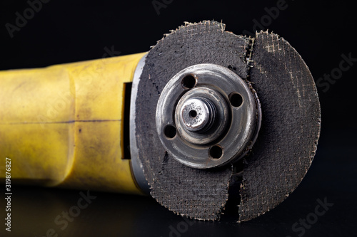 Damaged cutting disc for metal in an angle grinder. Power tools in a locksmith's workshop for repair.