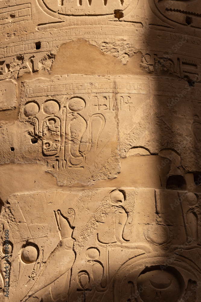 Karnak Temple, complex of Amun-Re. Embossed hieroglyphics on columns. Great Hypostyle Hall. Columns damaged by French vandal -soldiers during the colonization of Egypt. Karnak Temple, complex of Amun-Re. Embossed hieroglyphics on columns. Great Hypostyle Hall. Columns damaged by French vandal -soldiers during the colonization of Egypt.