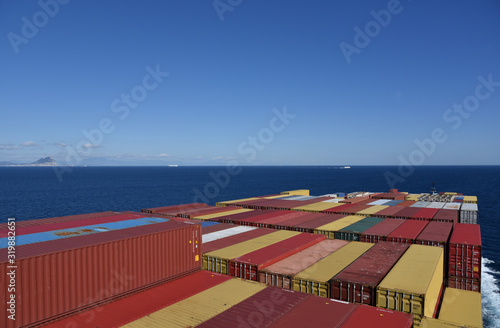 Containers loaded on the cargo ship sailing near sea through calm sea. 