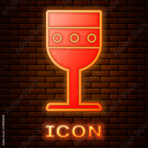Glowing neon Medieval goblet icon isolated on brick wall background. Vector Illustration
