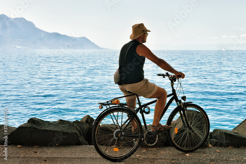 Man riding a bicycle at the embankment on Geneva Lake in Montreux, Vaud canton, Switzerland