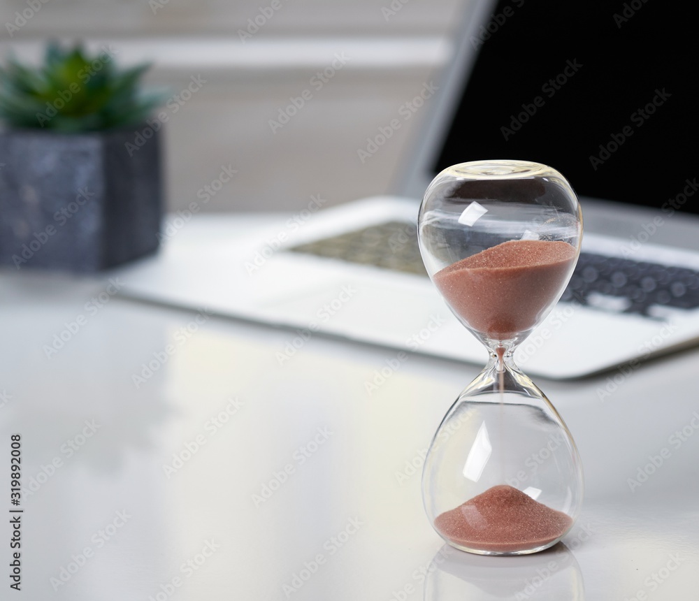 Hourglass on office desktop. Hourglass on office desktop.