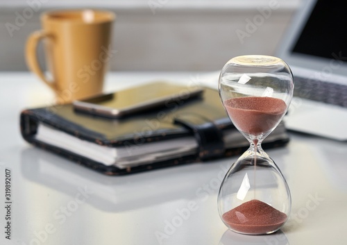 Hourglass on office desktop. photo