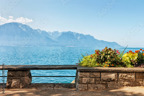 Bench and flowers blooming at the embankment of Geneva Lake in Montreux, Vaud canton, Switzerland