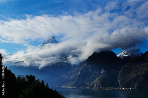 clouds and mountains with a lake in foreground near Brunnen