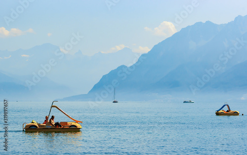 Lausanne, Switzerland - August 26, 2016: People in catamarans at Geneva Lake in Lausanne, Switzerland