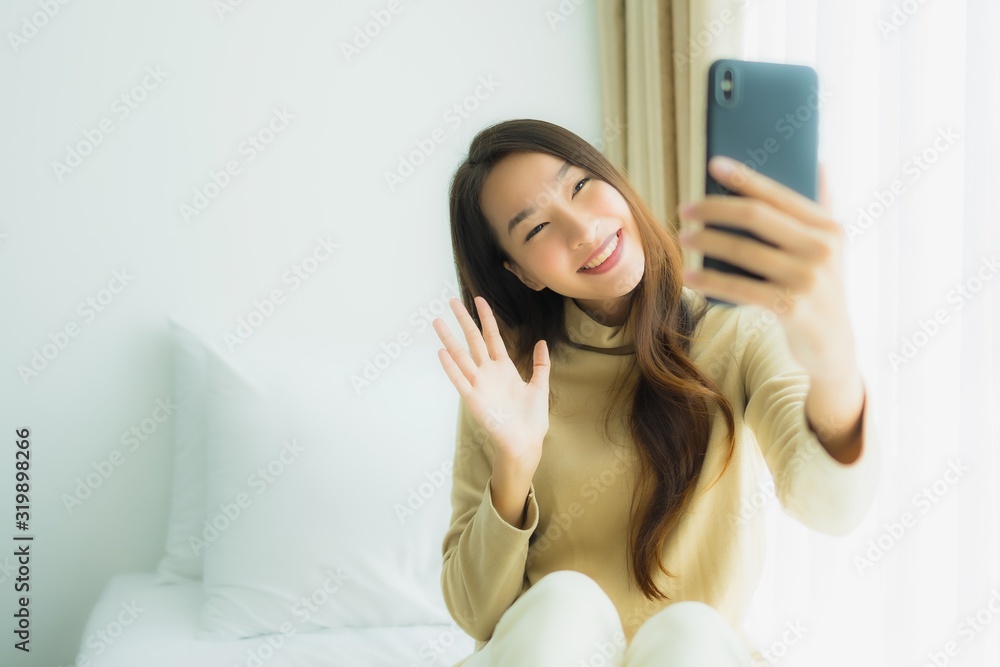 Young asian woman using mobile smart phone on bed Young asian woman using mobile smart phone on bed