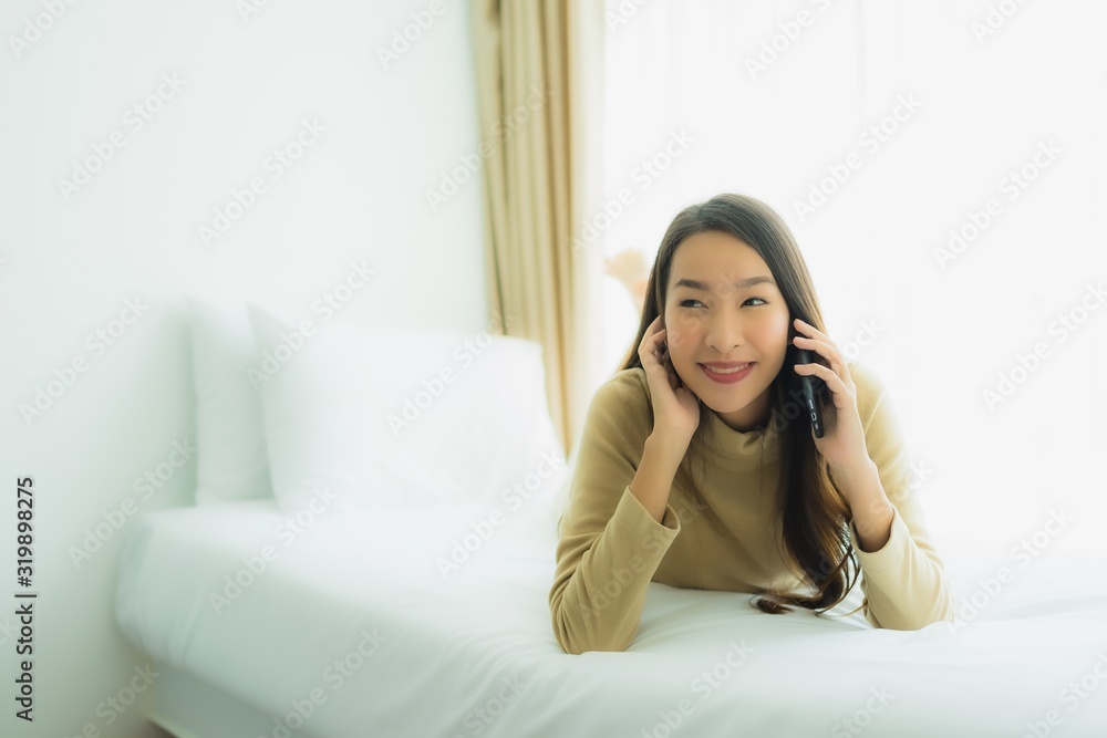 Young asian woman using mobile smart phone on bed Young asian woman using mobile smart phone on bed