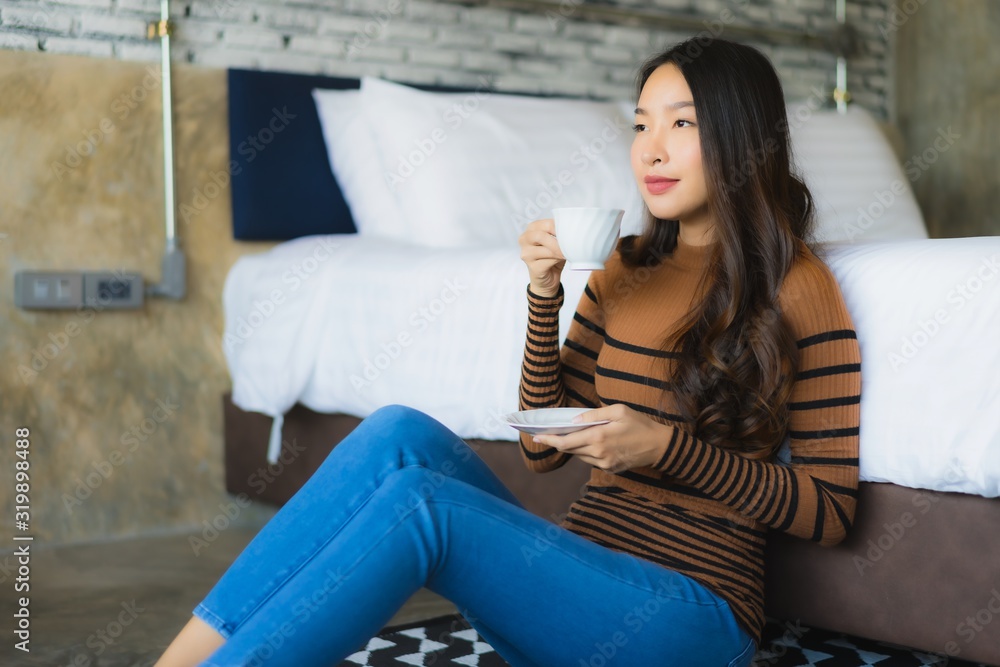 Obraz premium Young asian woman with coffee cup on bed