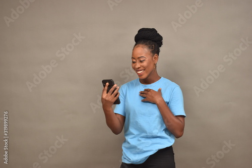 beautiful african girl using her mobile phone feeling happy and excited