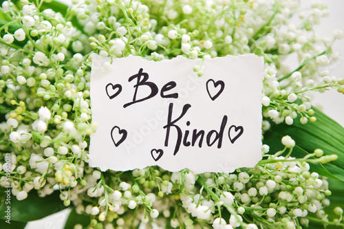 Be kind - calligraphy lettering with hearts in white flowers, motivation phrase about goodness © justesfir