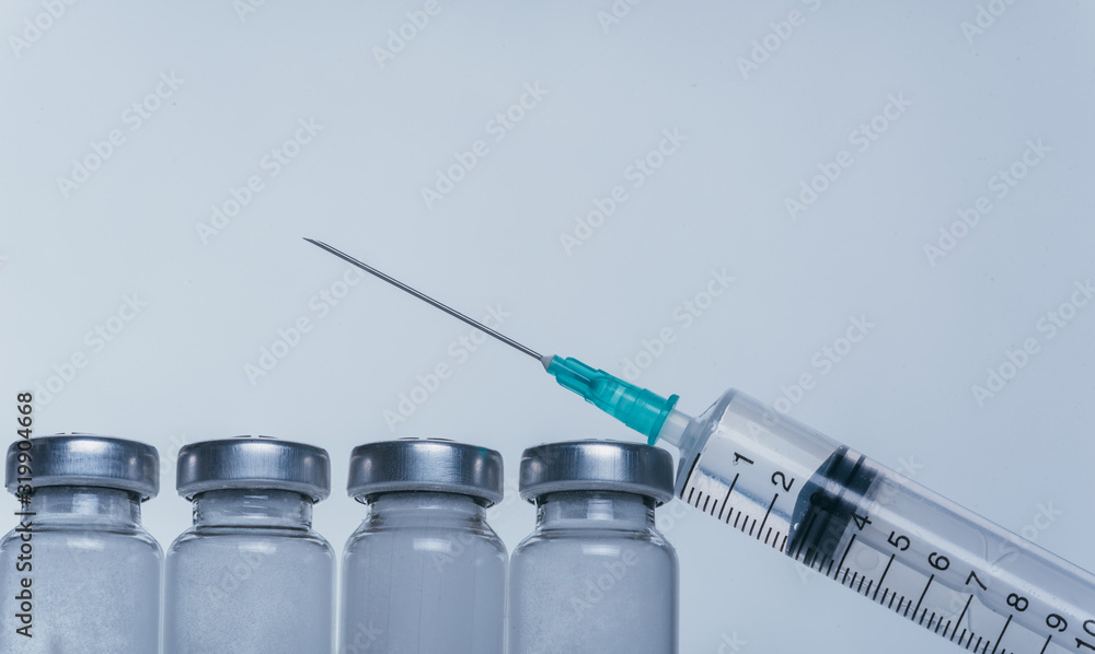 Medicine, Injection, vaccine and disposable syringe, drug concept. Sterile vial medical syringe needle. Macro close up. Glass medical ampoule vial for injection. Bottles ampule with aluminum cap. Medicine, Injection, vaccine and disposable syringe, drug concept. Sterile vial medical syringe needle. Macro close up. Glass medical ampoule vial for injection. Bottles ampule with aluminum cap.