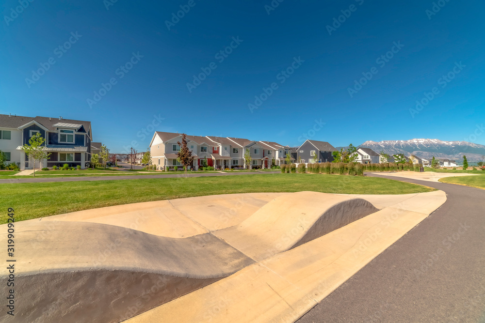 Focus on a ramp with houses snow capped mountain and blue sky in the background