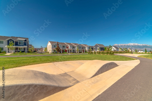 Focus on a ramp with houses snow capped mountain and blue sky in the background