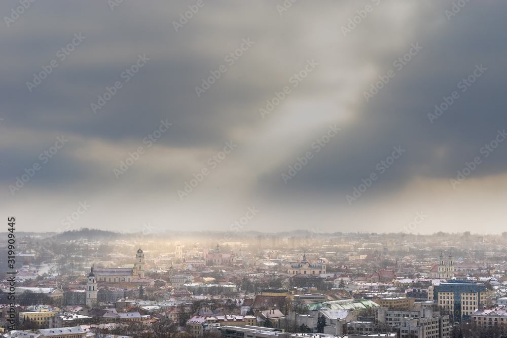 Wonderful panorama of Vilnius in winter with snow and sunshine: Old Town, many churches, residential and office buildings. Aerial view from the Municipal Building, from a height of 77 m. Copy space