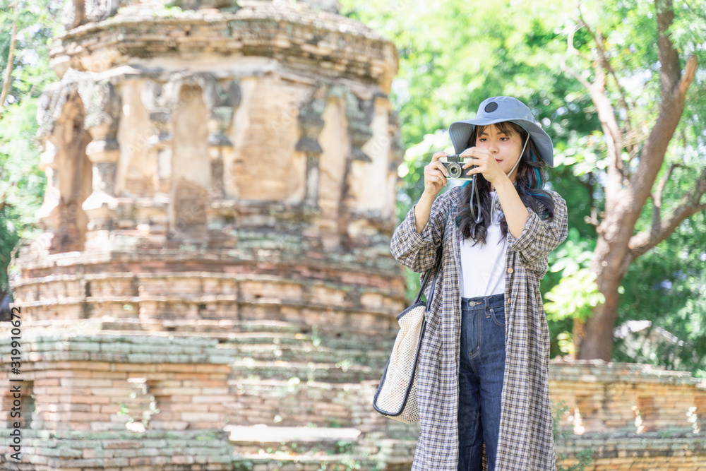 Young woman traveler traveling in old temple. Asian tourist concept