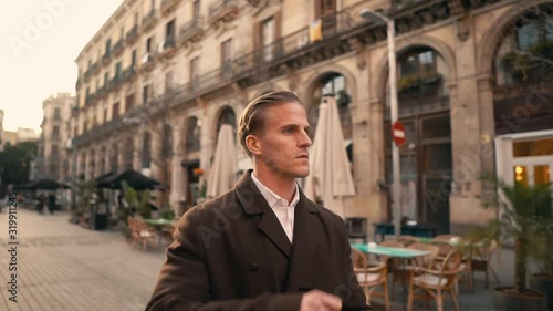 Old Fashion Man from the 1920s england walking along an old street of a historic city photo