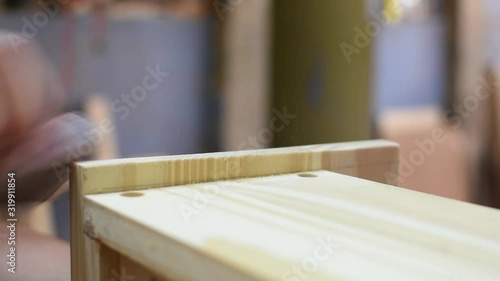 close up of a woman hand sanding a wooden box