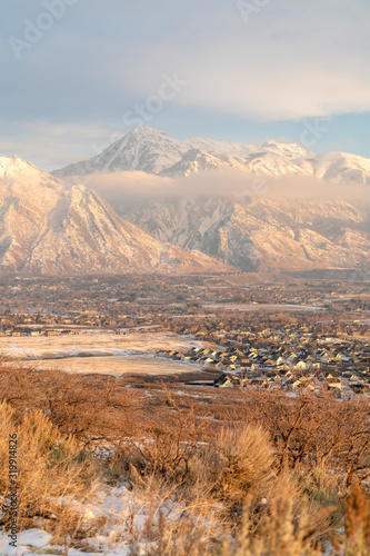 Mount Timpanogos hills and houses blanketed with snow on a cold winter day