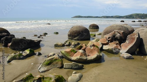 Moeraki boulders on Koekohe Beach on the Otago coast, New Zealand. One of the boulders in the foreground has disintegrated into pieces.