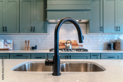 Quadro em tela Double bowl kitchen island sink with black faucet against cooktop and cabinets