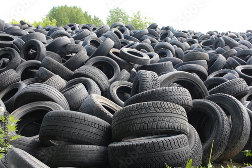 old unnecessary rubber tires from the wheels are disposed of a huge pile in a landfill pollutes nature with waste a danger to the environment