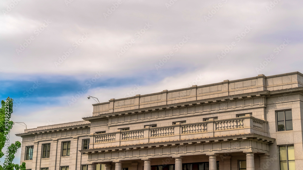 Panorama Building with white wall balcony and security camera on roof against cloudy sky