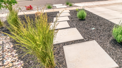 Panorama Landscaped yard with stone steps pathway that leads to the paved road