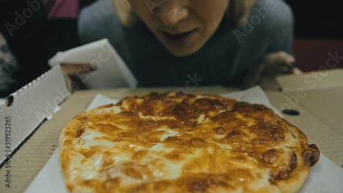 Girl eat pizza cheese four. Close up of young woman mouth greedily eating pizza and chewing in outdoor restaurant. Human hands taking pieces slices of hot tasty italian pizza from open box. Junk food. photo