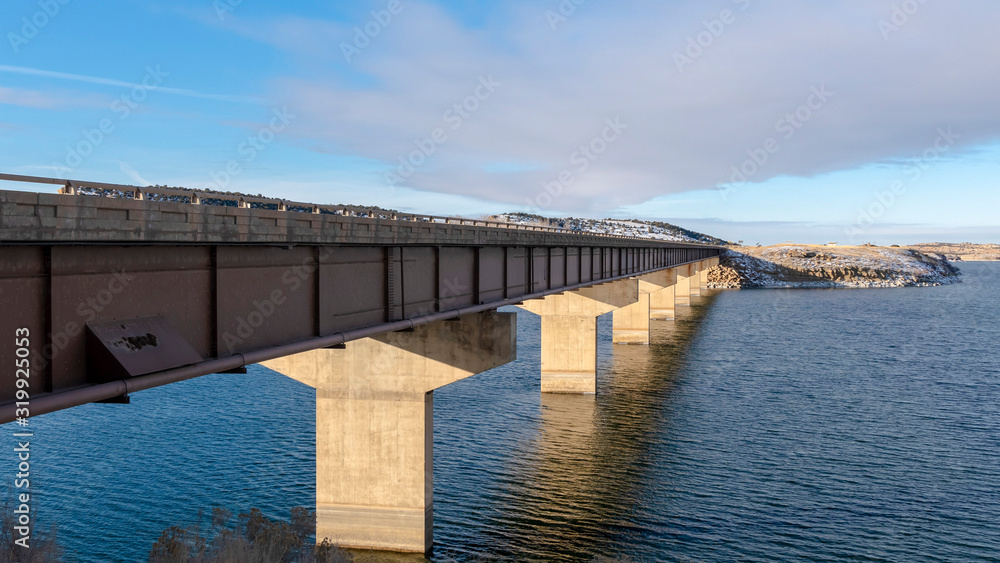 Panorama Bridge over a vast calm lake with snow covered shore during winter season Panorama Bridge over a vast calm lake with snow covered shore during winter season