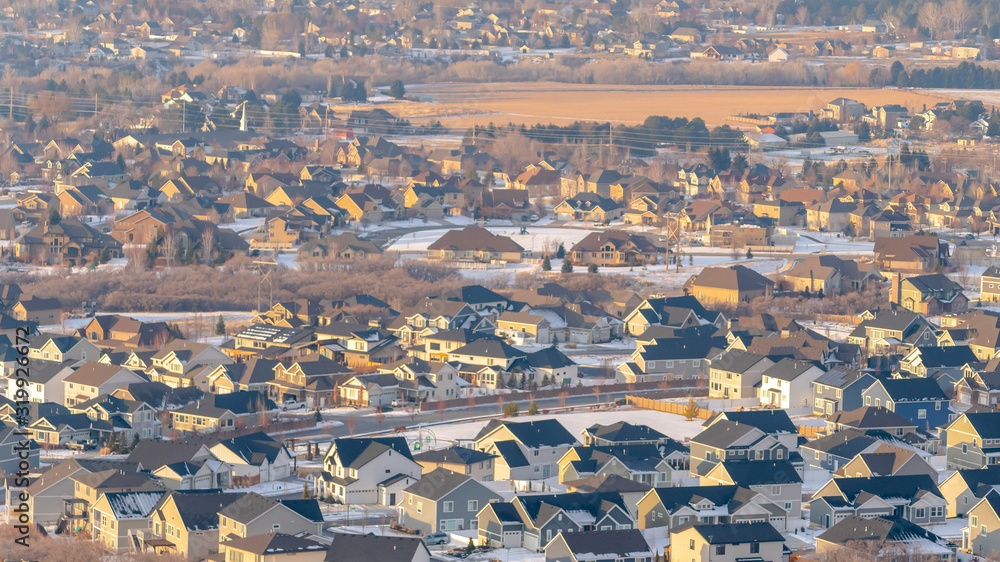 Panorama Tranquil neighborhood nestled amid hilly terrain covered with snow in winter