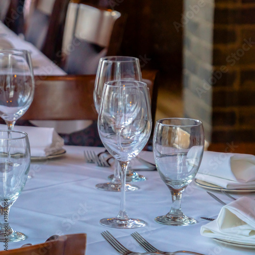 Square frame Tableware arranged on round table with white cloth for eating at an occasion