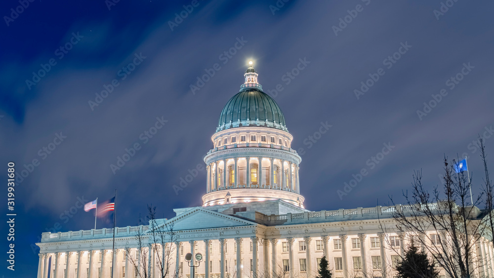 Panorama Facade of majestic Utah State Capital Building glowing against sky and clouds