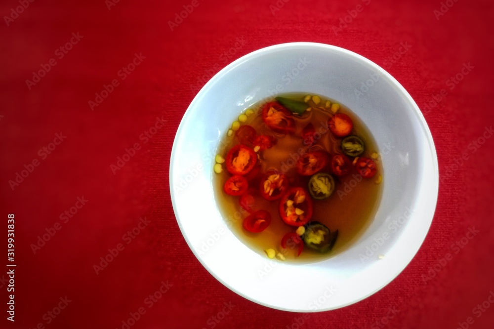 Spicy Red Chili Sauce in white bowl kept on red table at Bangkok Thailand Spicy Red Chili Sauce in white bowl kept on red table at Bangkok Thailand