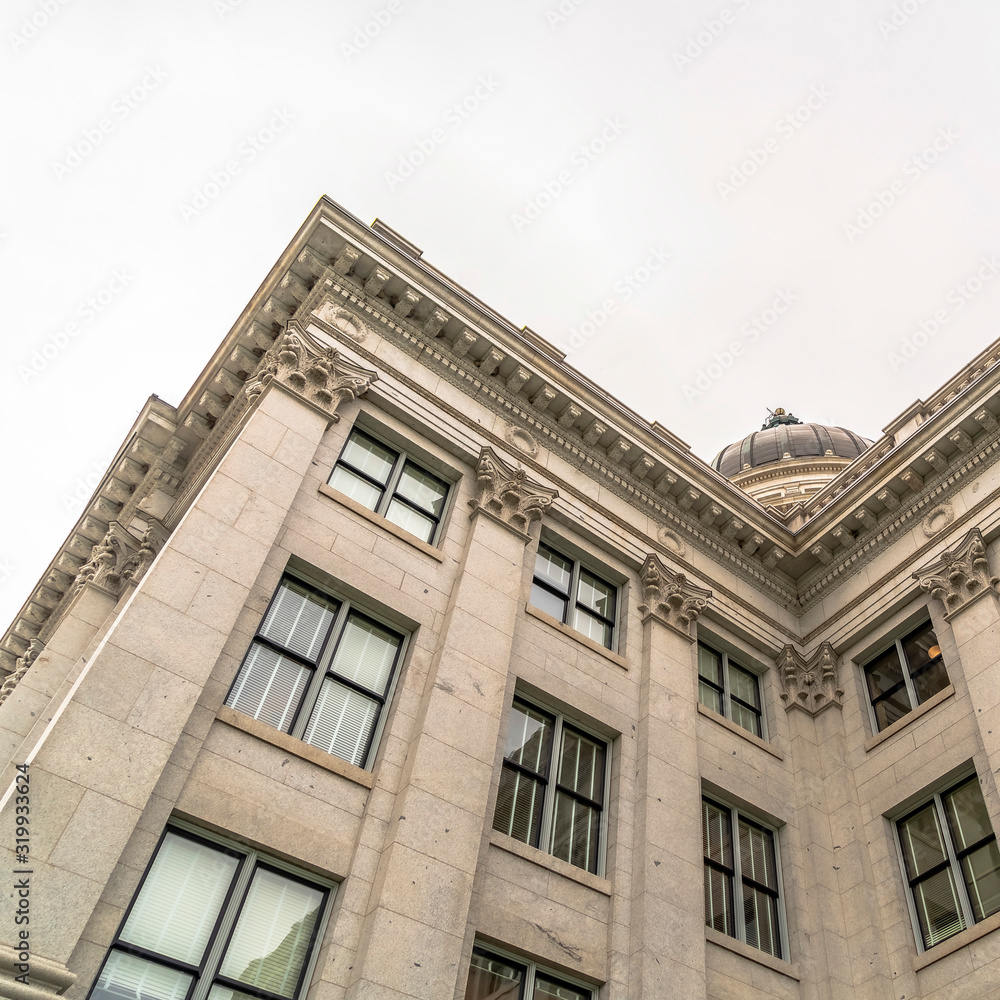 Square frame Utah State Capitol Building exterior with view of dome against overcast sky