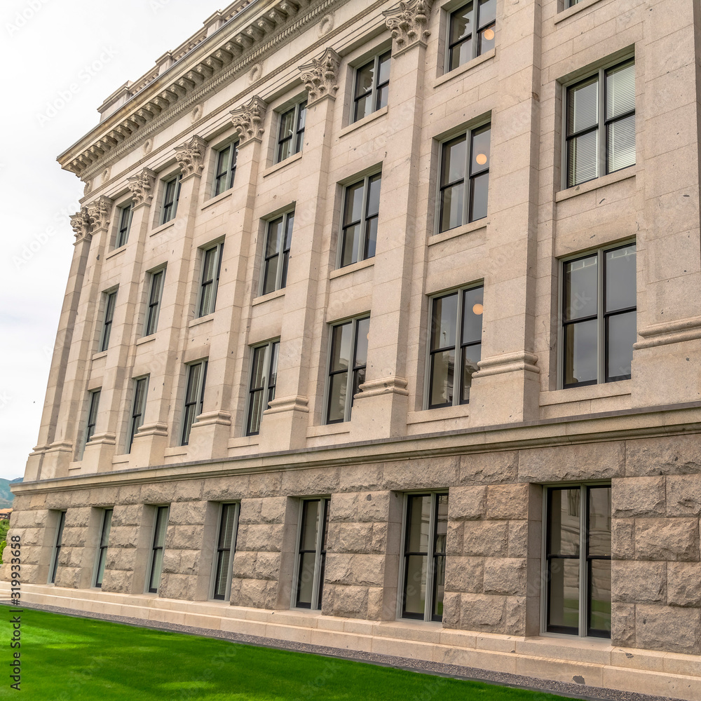 Square Building facade with decorative mouldings on the white stone exterior wall