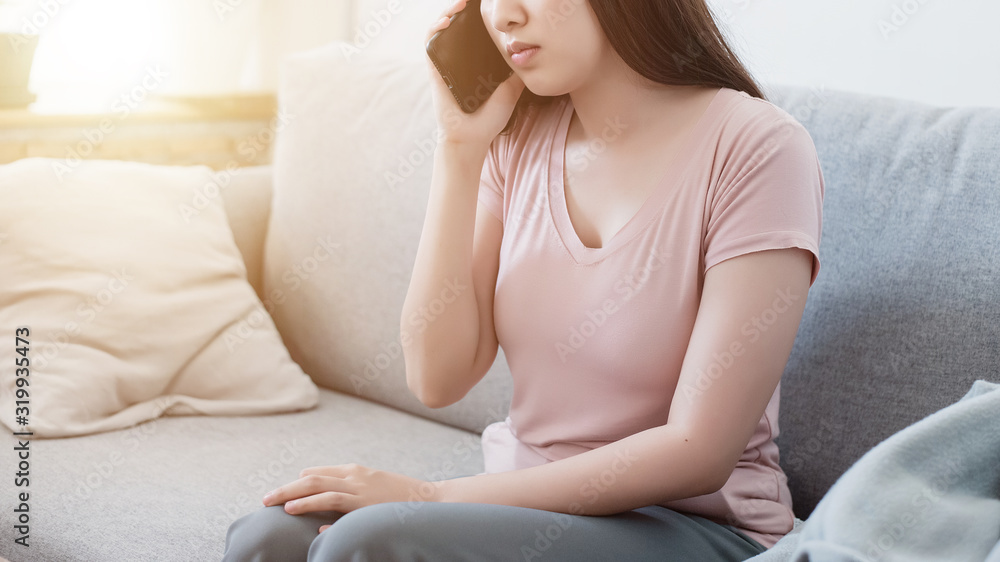 Asian woman in pink t-shirt hearing something bad from her mobile phone with sad face. Asian woman in pink t-shirt hearing something bad from her mobile phone with sad face.